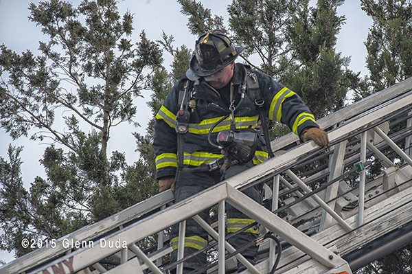 fireman climbing down aerial ladder