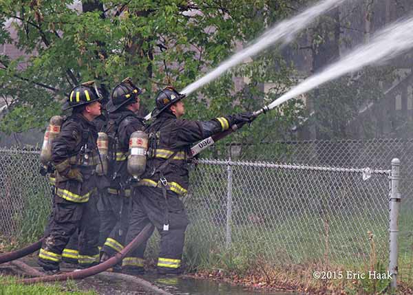firemen with hose lines a t fire scene
