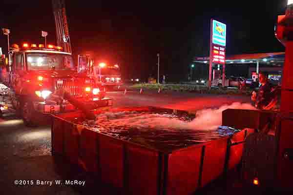 fire engine drafts from dump tank at fire scene