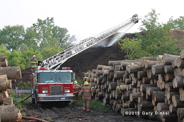 firemen in Canada fight fire in a huge mulch pile