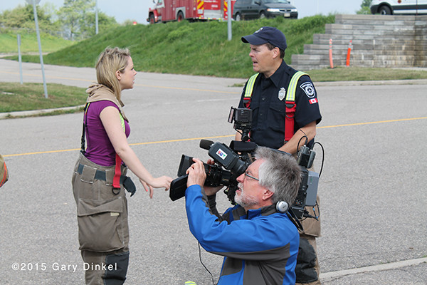 tv reporter reporting on firefighter training
