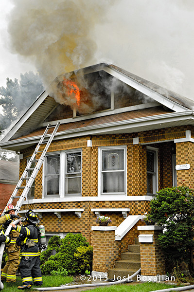 flames through attic of house on fire