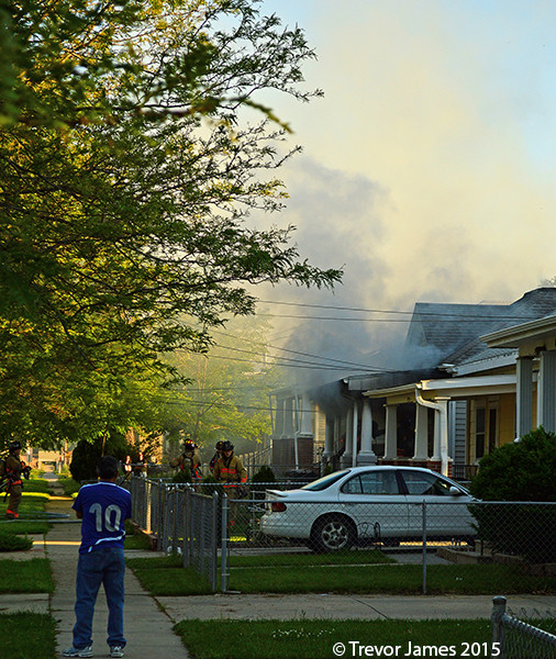 firemen at a small neighborhood house fire