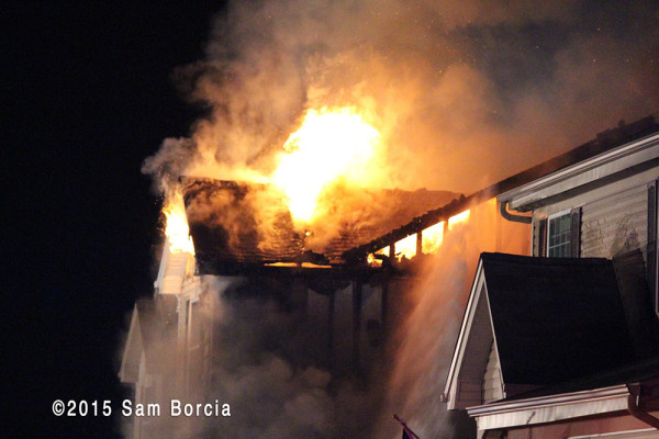 flames through roof of house at night
