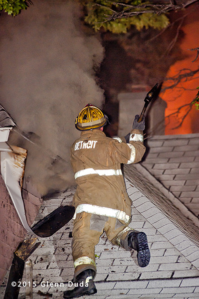 fireman on roof with smoke and flames