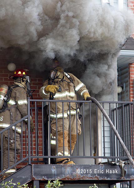 firemen immersed in smoke at doorway