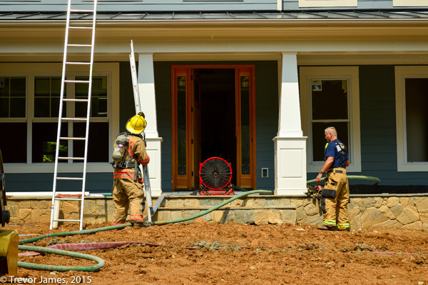 firemen survey a house after a fire