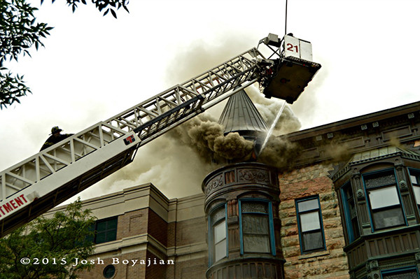 firefighters use tower ladder to battle a fire