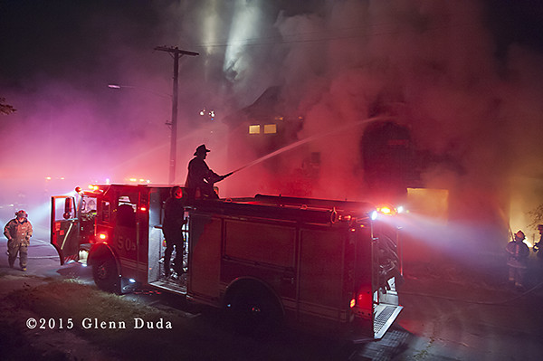 Detroit firemen silhouetted at night fire scene