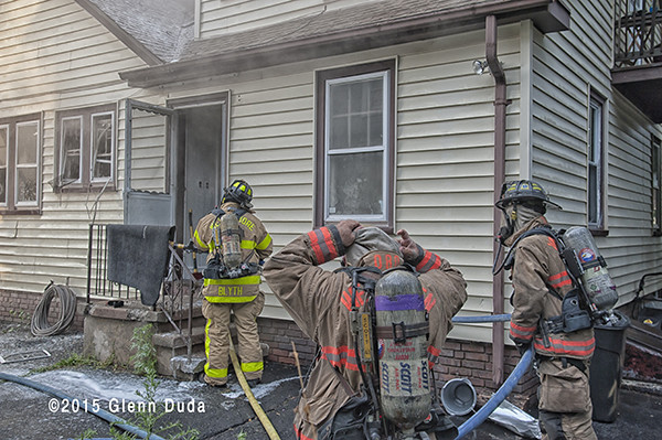 firemen donning SCBA to enter house fire
