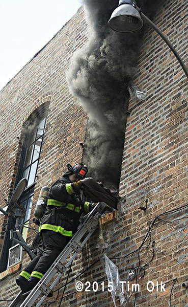 fireman on ladder at window with smoke