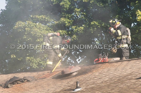 firemen vent roof during house fire