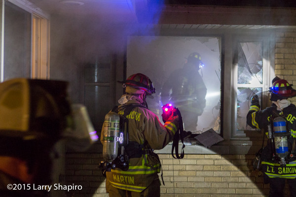 fireman with flashlight at night fire scene