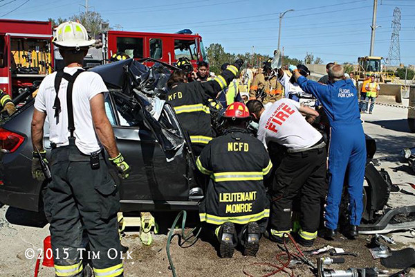 firefighters work to free a driver trapped after a crash