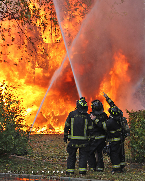 firefighters with hose at massive fire