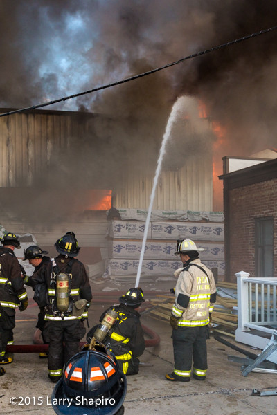 firemen with master stream at lumber yard fire