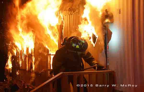 firefighter breaching door of a single wide mobile home on fire