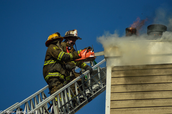 firemen on ladder with saw