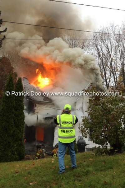 fire blowing out of attic of a house