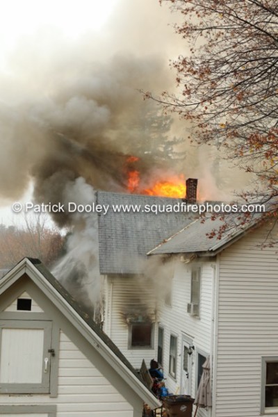 fire blowing out of attic of a house