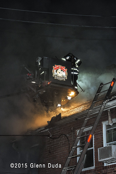 firefighters at night in tower ladder basket