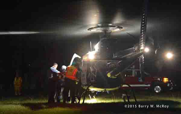 paramedics transfer patient to medevac helicopter at night