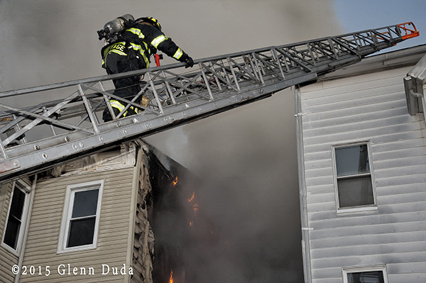 firefighter climbs aerial ladder at fire