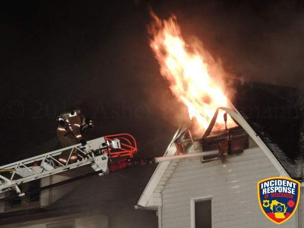 flames from attic of house at night