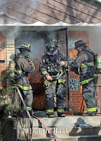 firemen make entry at house fire