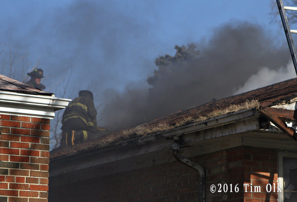 firefighter vents roof at house fire