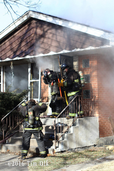 firefighters prepare to make entry at house fire