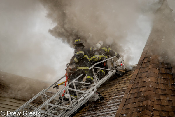 firemen vent roof at fire scene