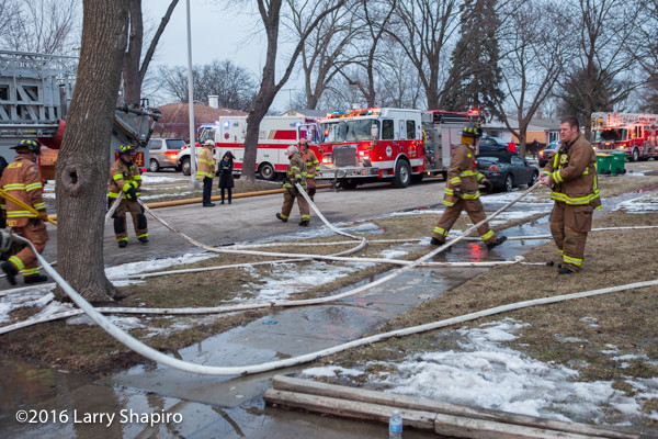 firemen pickup hose after battling a fire