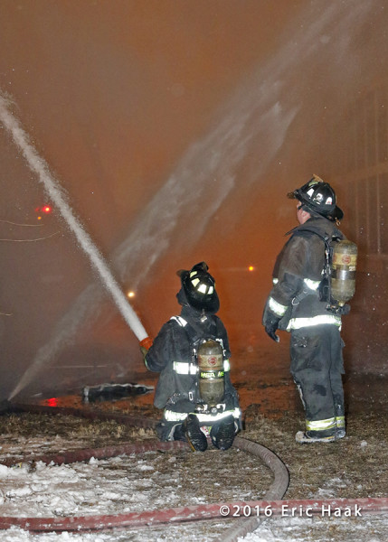 firemen with hose at fire scene