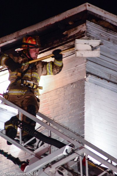 firefighter on ladder tip doing overhaul