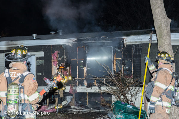 firefighters battle a mobile home fire