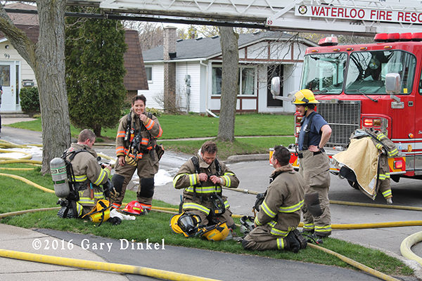 firefighters relax after a house fire in Waterloo Ontario