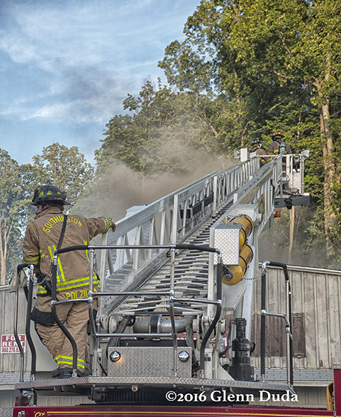 firefighter at base of aerial ladder