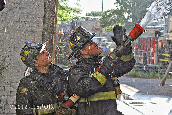 Chicago firefighters with a hose line