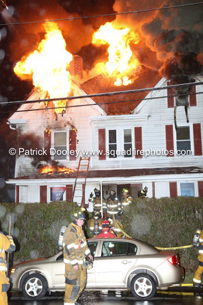 flames through roof of house at night
