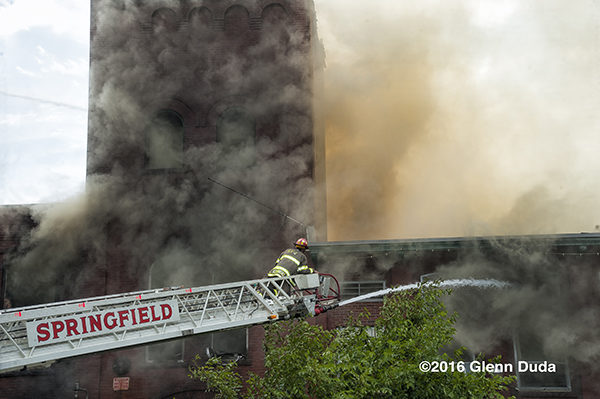 firefighter on aerial ladder tip at fire scene