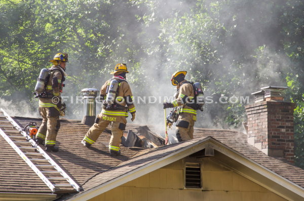 firefighters on roof after cutting a vent 