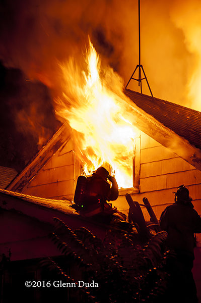 silhouette of firefighters on roof