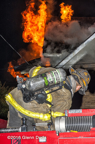 Detroit firefighter on engine at night