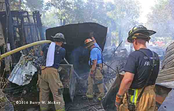 firefighters overhaul rural fire scene