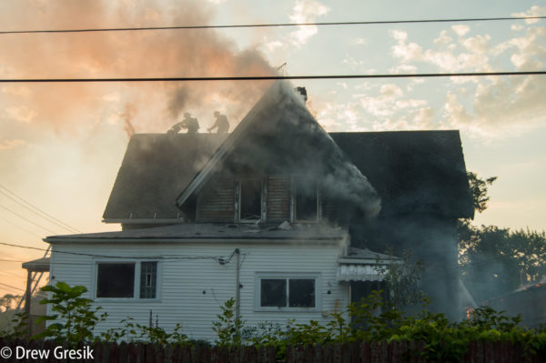 firefighters on the roof during a house fire
