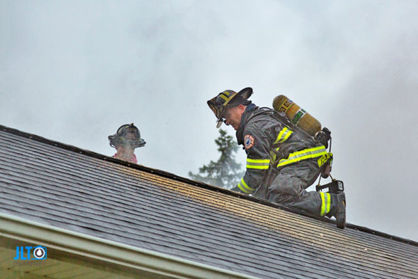 firefighter ventilates roof during fire