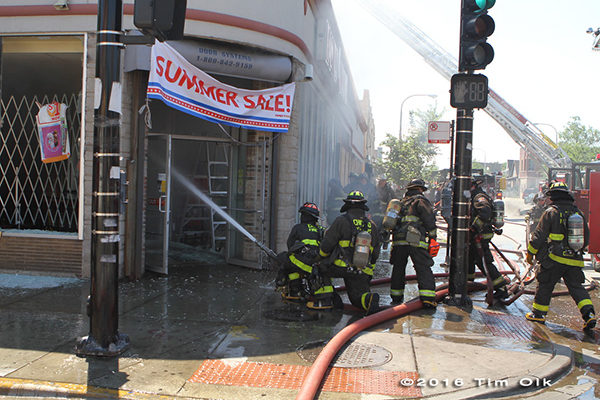 firefighters with hose line at building fire