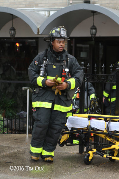 firefighter in PPE with tools after a fire