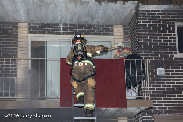firefighter climbs ladder to balcony